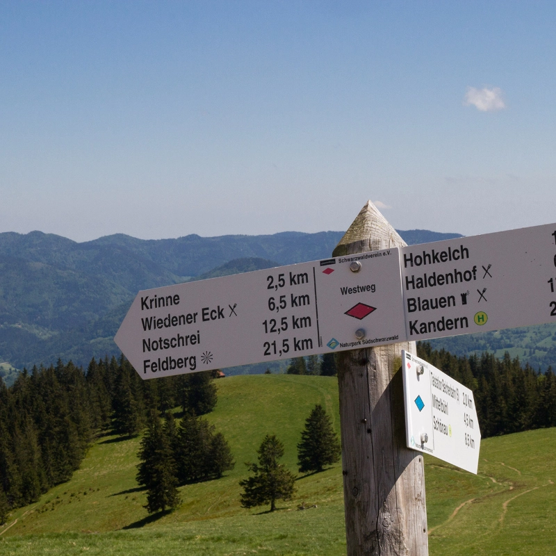 Schild zur Kennzeichung der Wanderwege vor Schwarzwaldkulisse