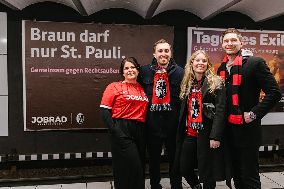 Gruppe SC-Fans vor Plakat "Braun darf nur St. Pauli" in U-Bahn Station